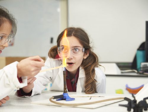 child in science class with bunsen burner