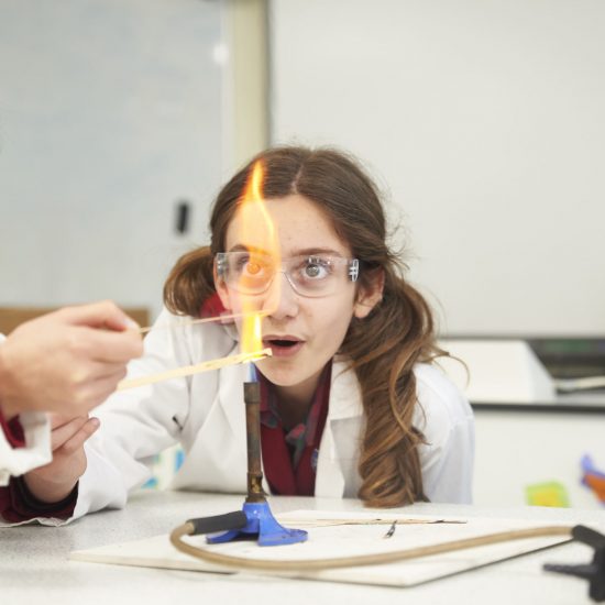child in science class with bunsen burner